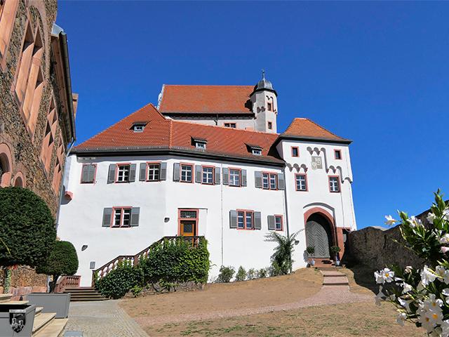 Hinter dem Burgtor der Burg Alzenau eröffnet sich der Blick auf den Vorhof und den Torturm mit Anbau zur Kernburg hin. 
